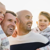 family of two kids and two fathers looking happy