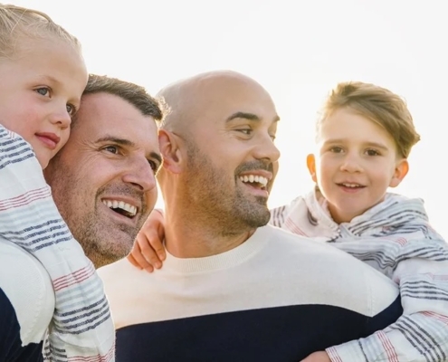 family of two kids and two fathers looking happy