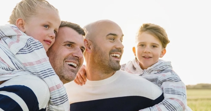 family of two kids and two fathers looking happy