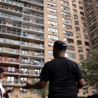 three people outside large apartment complex