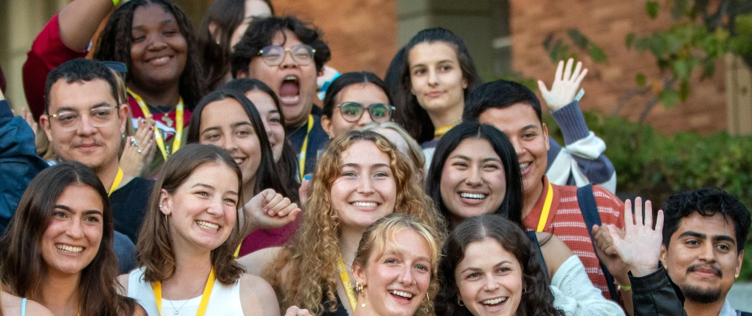 Group of students smiling and waving