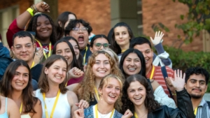 Group of students smiling and waving