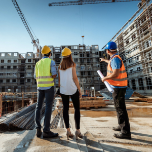 Employees working on construction site, wearing protective equipment and discussing next construction phase