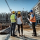 People working on construction site, wearing protective equipment and discussing next construction phase