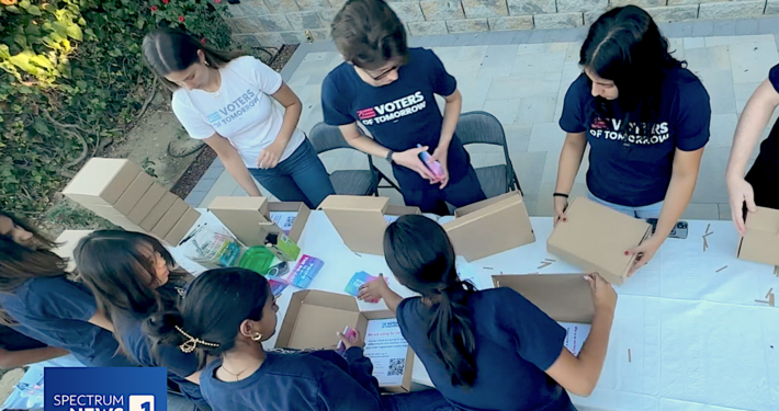 youth filling small cardboard boxes with written material