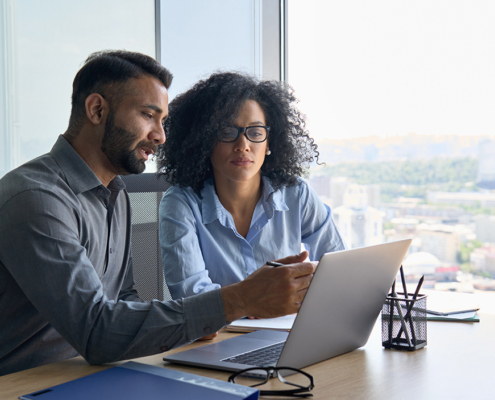 A man and a woman looking at a laptop together