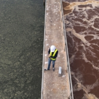 worker on platform at wastewater treatment plant