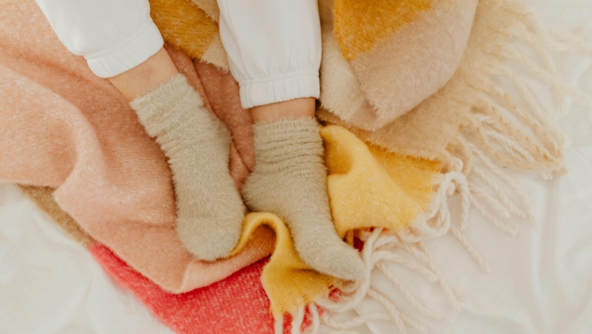 fuzzy socks on feet set against blanket