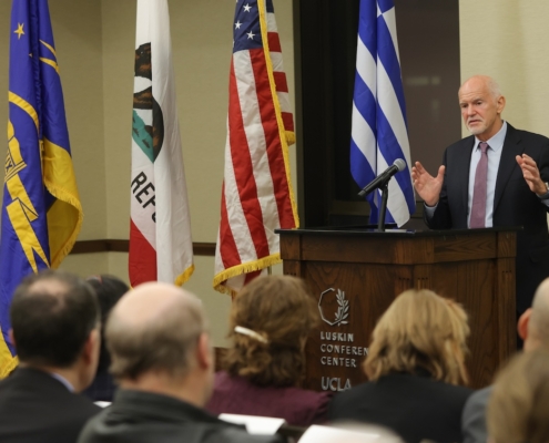 Former Greek prime minister George Papandreou speaking at UCLA. Greek flag and U.S. flag are behind him