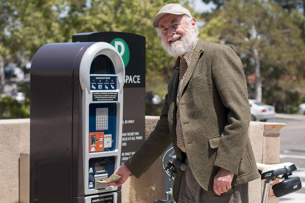 Man at parking kiosk|Man in sweater in front of bookcase