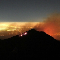 flames and smoke above lights of Los Angeles