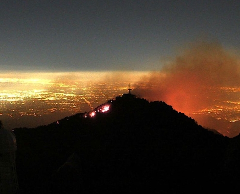 flames and smoke above lights of Los Angeles