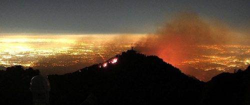 flames and smoke above lights of Los Angeles