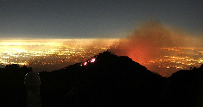 flames and smoke above lights of Los Angeles