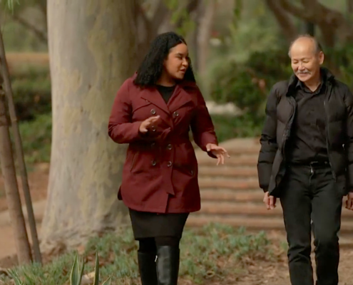 woman in maroon coat and man in black coat walking outdoors