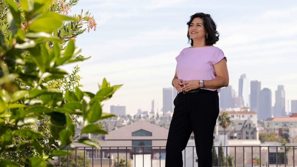 Woman in pink top with L.A. skyline in background