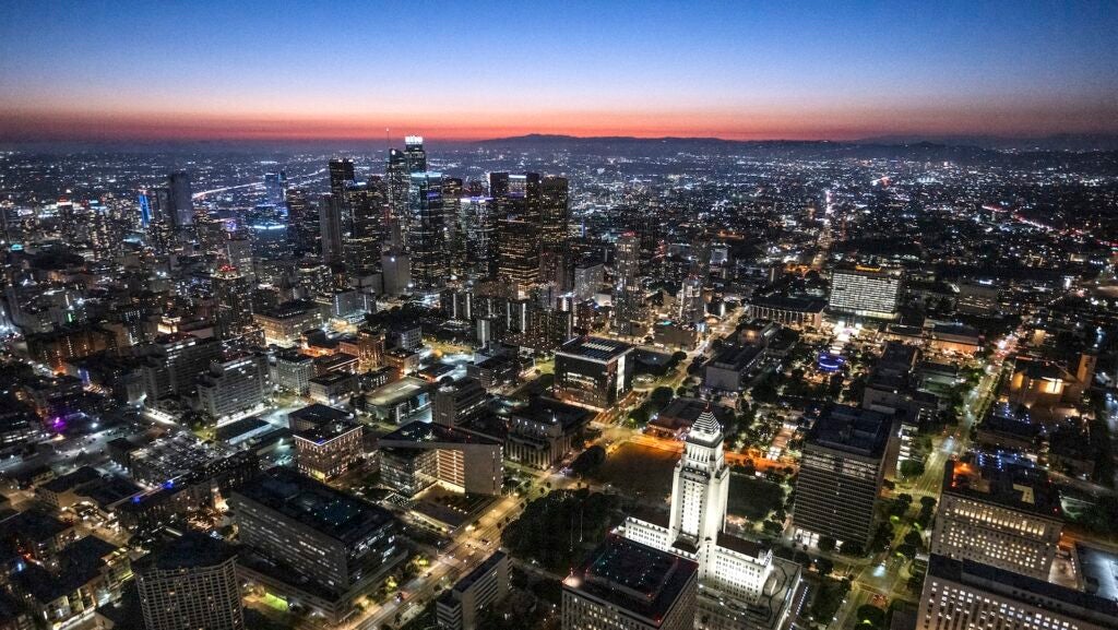 Downtown LA just after sunset during blue hour, captured from a helicopter point of view with lighted City Hall building.