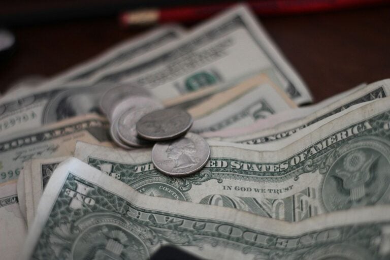A few coins on top of several one dollar bills