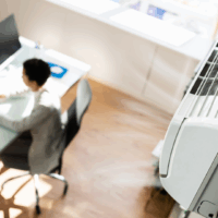 Indoor Heat Edith de Guzman Faculty in the News A person working at a desk with a wall mount air conditioner in the frame/