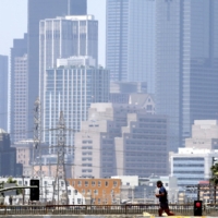 Latino Neighborhoods Photo of a man jogginb across the street with the background of Los Angeles cityscape in the scorching heat