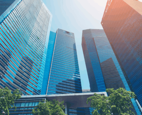 A photo of tall skycrapers coming a semi circle on a bright sunny day with the shadow of some of the building being cast on a few.