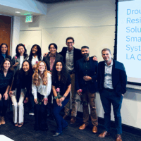 Group of masters in urban and regional planning students stand with their advisors on their capstone presentation day.