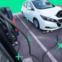 Smart Car Plug In Electric car parked in a parking lot that is plugged in to a charging port
