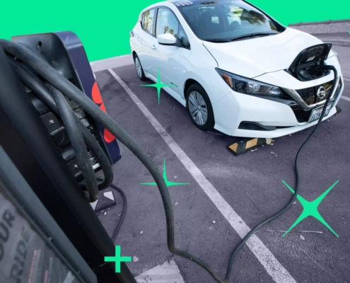 Electric car parked in a parking lot that is plugged in to a charging port