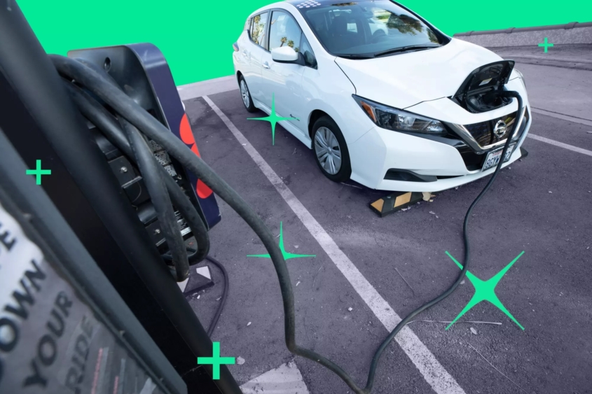Electric car parked in a parking lot that is plugged in to a charging port