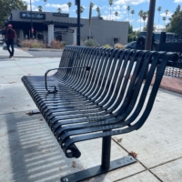 Bus Bench Photo for Hostile Architecture Bus stop steel bench with a metal armrest in the middle to deter people from laying down.