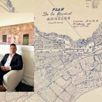 Photo of Edgar Garcia sitting on a couch over a large map of Los Angeles.