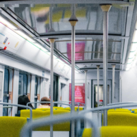 Interior shot of a Paris public transit train with some passengers seated.