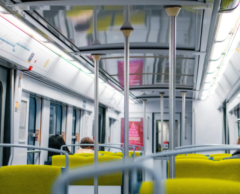 Interior shot of a Paris public transit train with some passengers seated.
