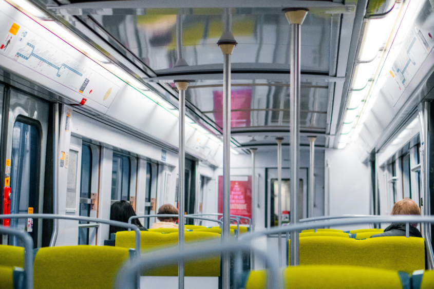 Interior shot of a Paris public transit train with some passengers seated.