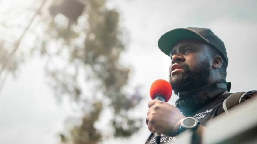 Photo of David C. Turner with a microphone and baseball cap.