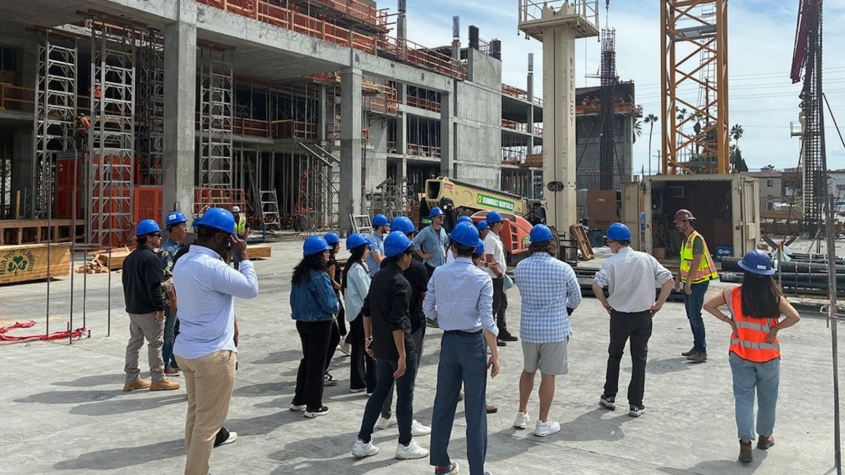 Students in blue hard hats at construction site