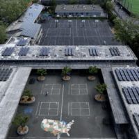 Aerial view of school campus with solar panels on roofs.