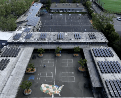 Aerial view of school campus with solar panels on roofs.