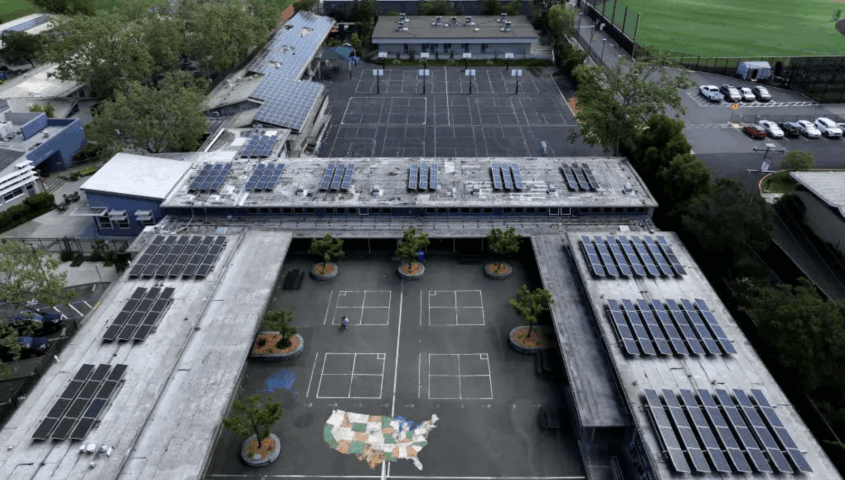 Aerial view of school campus with solar panels on roofs.