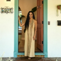 Tamika Lewis stands at the doorway entrance in front of the Women of Color Therapy and Wellness Center