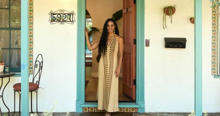 Tamika Lewis stands at the doorway entrance in front of the Women of Color Therapy and Wellness Center
