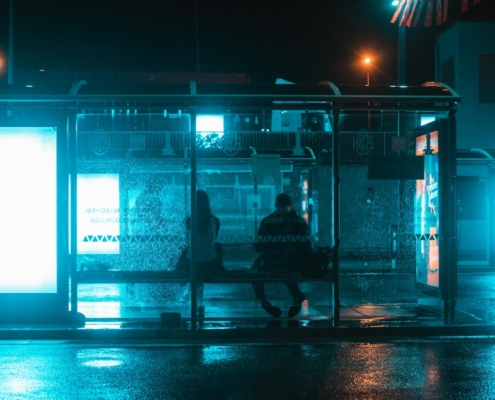 two people at bus stop at night