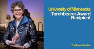 Photo of Barbara Nelson holding her Torchbearer Award at the ceremony