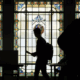 silhouette of voters against stained-glass background