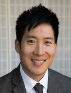 Headshot of man in suit, white shirt, tie