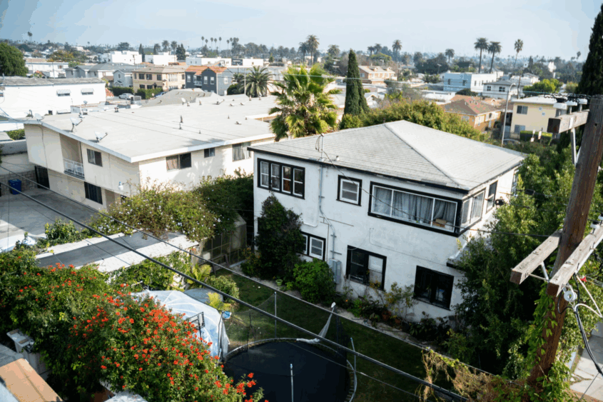 An aerial shot of a Los Angeles neighborhood, photo of a white apartment building.