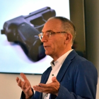 Professor Mark Kaplan speaks in class about firearm suicides and behind him is an image of a gun on the projector.