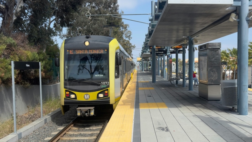 A yellow metro train at a station.