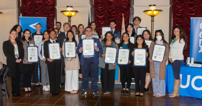 Luskin students hold up their certificates in a group photo on City Hall at Luskin.