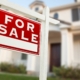For sale home sign in front of a new construction home.